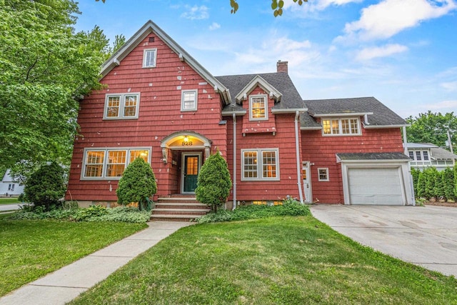 928 Emilie St, Green Bay, WI 54301 - view of front facade with a chimney, concrete driveway, a garage, and a front lawn