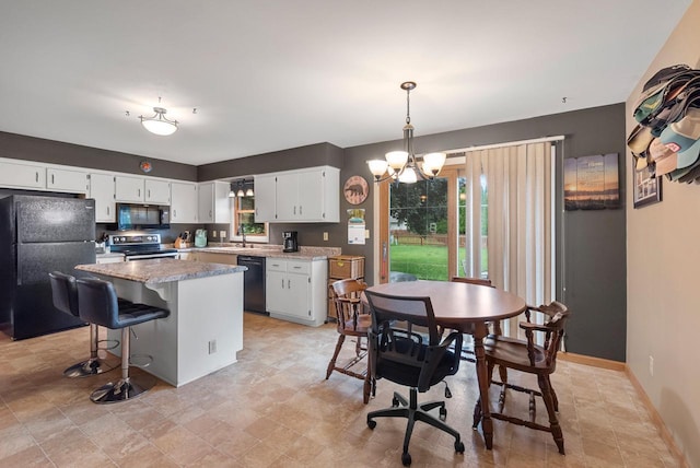 3987 Elaines Way, Slinger, WI 53086 - kitchen with black appliances, a chandelier, white cabinetry, a kitchen island, and decorative light fixtures