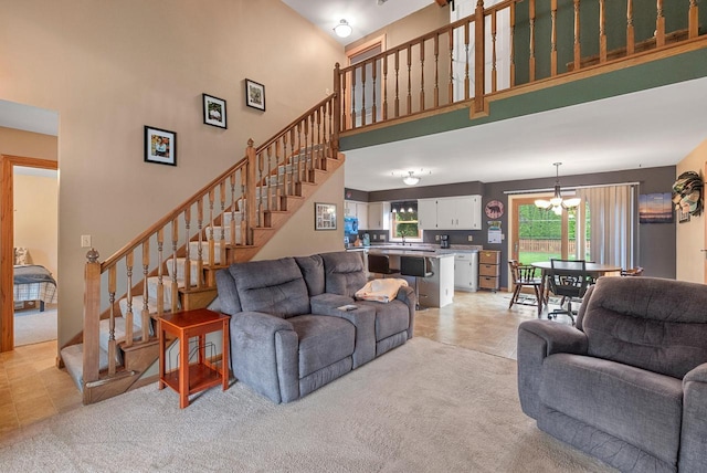 3987 Elaines Way, Slinger, WI 53086 - living area with a high ceiling, a chandelier, stairs, light carpet, and light tile patterned floors