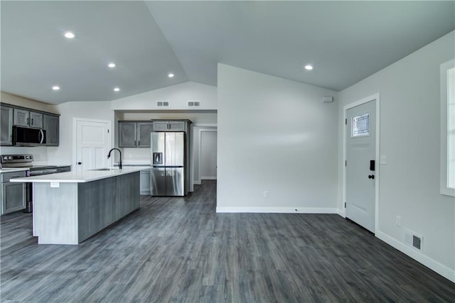 1688 Dorret Rd, Eau Claire, WI 54703 - kitchen with stainless steel appliances, lofted ceiling, light countertops, a center island with sink, and dark wood finished floors