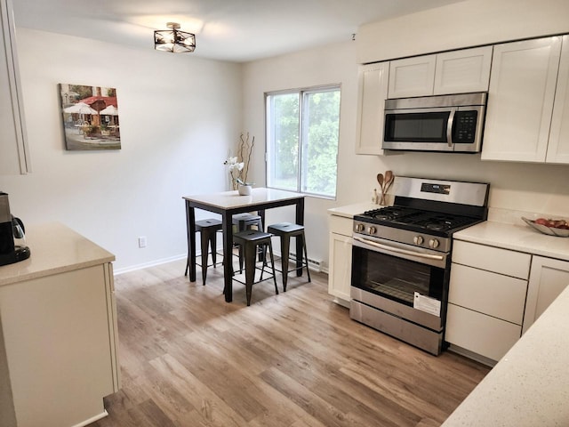 1239 Erick St, Fort Atkinson, WI 53538 - kitchen featuring appliances with stainless steel finishes, light wood-style flooring, and white cabinets