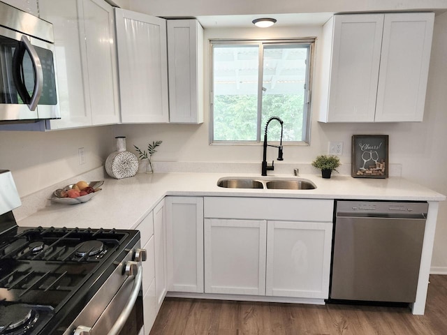 1239 Erick St, Fort Atkinson, WI 53538 - kitchen with appliances with stainless steel finishes, white cabinets, wood finished floors, and light countertops