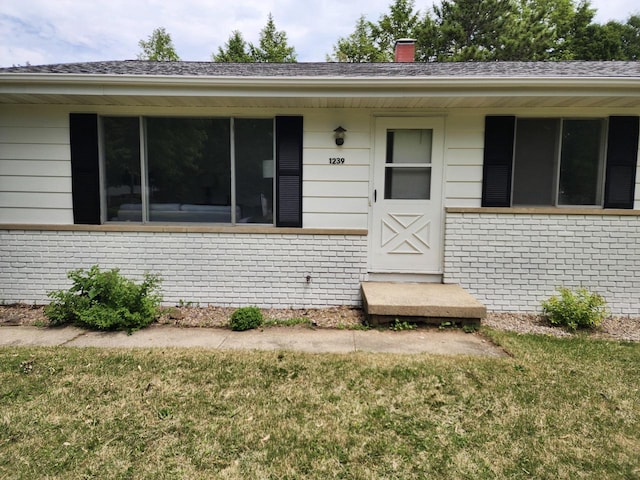 1239 Erick St, Fort Atkinson, WI 53538 - entrance to property with brick siding, a yard, and a chimney