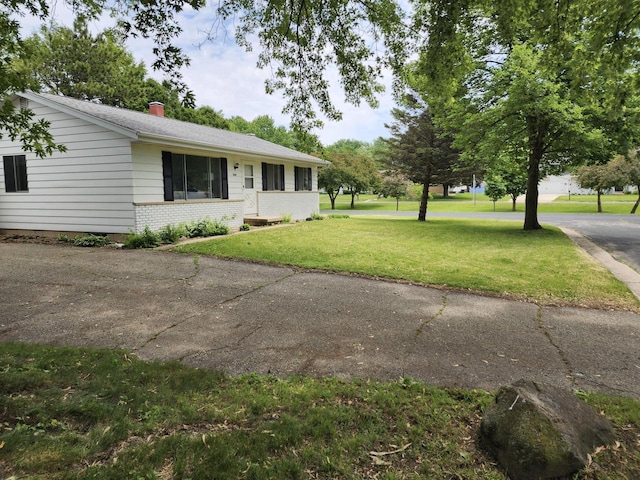 1239 Erick St, Fort Atkinson, WI 53538 - view of front of home featuring a chimney, a front lawn, and brick siding
