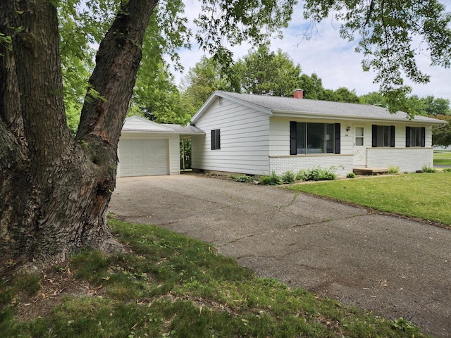 1239 Erick St, Fort Atkinson, WI 53538 - ranch-style home with asphalt driveway, a front yard, a chimney, brick siding, and a garage