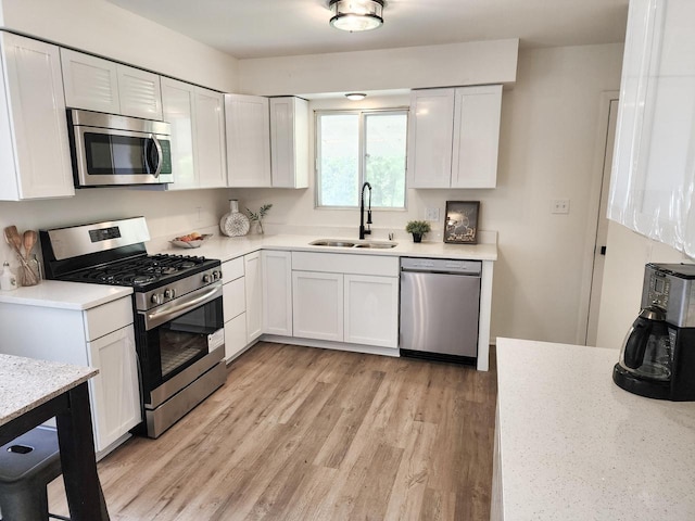 1239 Erick St, Fort Atkinson, WI 53538 - kitchen with appliances with stainless steel finishes, white cabinets, light wood-type flooring, and light stone counters