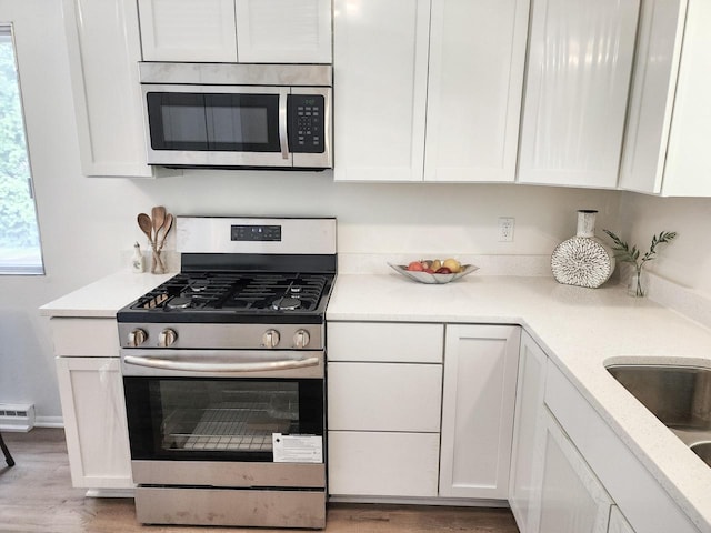 1239 Erick St, Fort Atkinson, WI 53538 - kitchen featuring stainless steel appliances, white cabinets, and light countertops