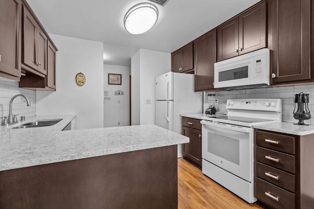 2524 Village Ln Unit B, Oshkosh, WI 54904 - kitchen featuring white appliances, decorative backsplash, and dark brown cabinets