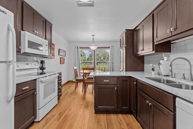 2524 Village Ln Unit B, Oshkosh, WI 54904 - kitchen featuring white appliances, tasteful backsplash, light wood-style flooring, and dark brown cabinets