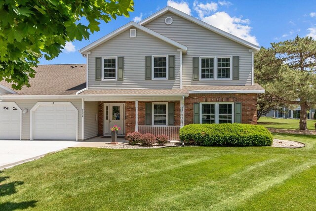 2524 Village Ln Unit B, Oshkosh, WI 54904 - traditional-style house featuring covered porch, a garage, a front yard, brick siding, and driveway