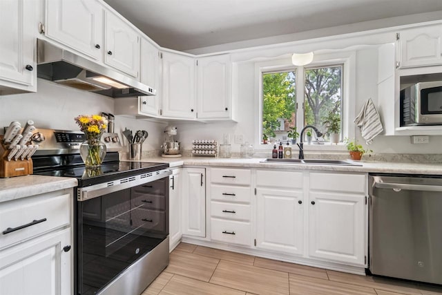 266 E 10th St, Fond Du Lac, WI 54935 - kitchen featuring appliances with stainless steel finishes, under cabinet range hood, white cabinets, and light countertops