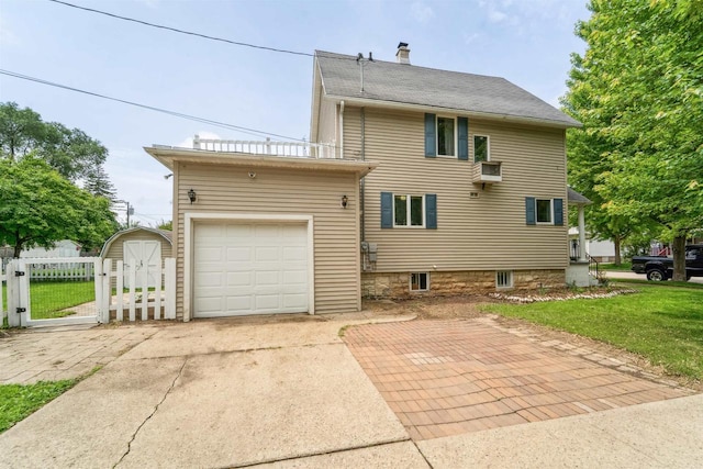 266 E 10th St, Fond Du Lac, WI 54935 - rear view of house featuring a chimney, an attached garage, a gate, and driveway