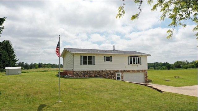 8519 Pigeon Lake Rd, Valders, WI 54245 - view of property exterior featuring concrete driveway, an attached garage, a yard, and stone siding