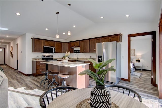 1724 Dorret Rd, Eau Claire, WI 54703 - kitchen with appliances with stainless steel finishes, light wood-style flooring, lofted ceiling, a center island, and pendant lighting