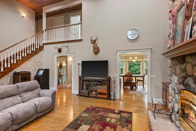 704 Sandy Pines Ct, Redgranite, WI 54970 - living area featuring a high ceiling, arched walkways, stairway, a stone fireplace, and wood finished floors