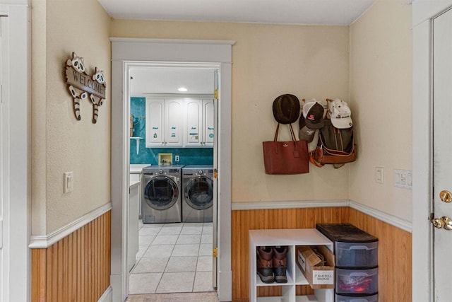 704 Sandy Pines Ct, Redgranite, WI 54970 - washroom featuring washing machine and clothes dryer, cabinet space, wainscoting, light tile patterned floors, and wood walls
