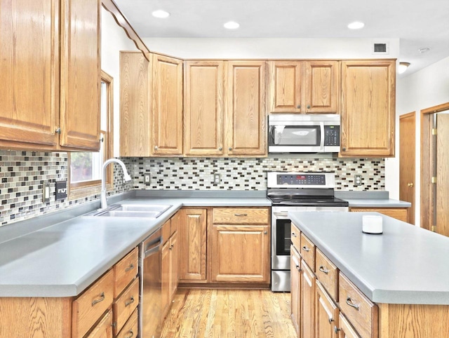 4315 Tanglewood Dr, Janesville, WI 53546 - kitchen with stainless steel appliances, light wood-type flooring, light countertops, tasteful backsplash, and recessed lighting