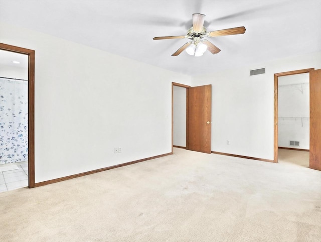 4315 Tanglewood Dr, Janesville, WI 53546 - unfurnished bedroom featuring light carpet, a spacious closet, ensuite bathroom, a ceiling fan, and a closet