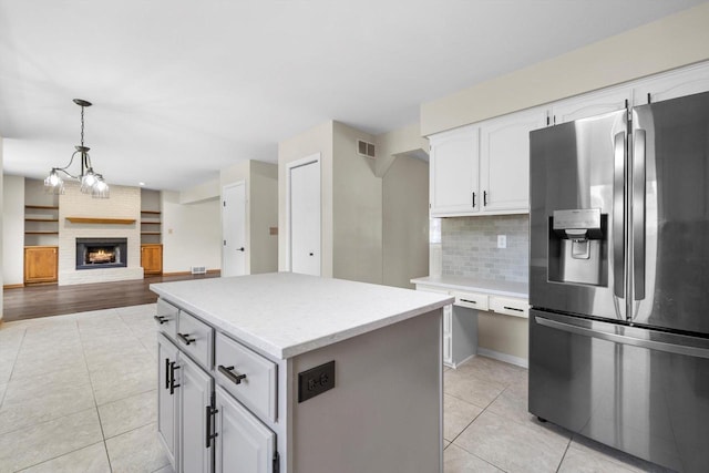 8206 41st Ave, Kenosha, WI 53142 - kitchen featuring stainless steel fridge with ice dispenser, light tile patterned floors, a kitchen island, and tasteful backsplash