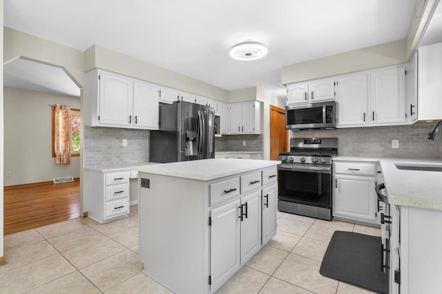8206 41st Ave, Kenosha, WI 53142 - kitchen with stainless steel appliances, light tile patterned floors, a center island, white cabinetry, and light countertops