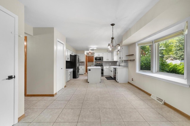 8206 41st Ave, Kenosha, WI 53142 - kitchen with appliances with stainless steel finishes, light countertops, decorative backsplash, a chandelier, and light tile patterned floors