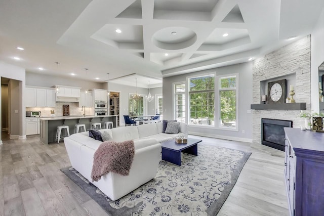9335 223rd Ave, Salem, WI 53168 - living room featuring a stone fireplace, coffered ceiling, recessed lighting, light wood finished floors, and a chandelier