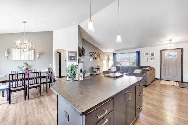 582 Clay St, Wrightstown, WI 54180 - kitchen with arched walkways, light wood-type flooring, a chandelier, dark countertops, and high vaulted ceiling