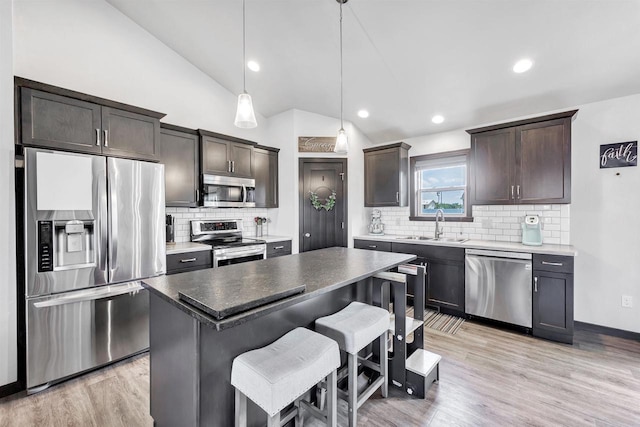 582 Clay St, Wrightstown, WI 54180 - kitchen featuring appliances with stainless steel finishes, dark brown cabinetry, a breakfast bar, a center island, and backsplash