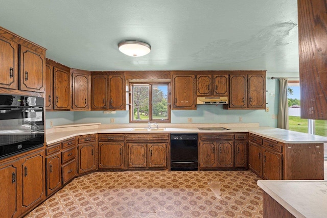1490 Fernando Dr, Ashwaubenon, WI 54115 - kitchen featuring black appliances, under cabinet range hood, light countertops, a peninsula, and brown cabinetry