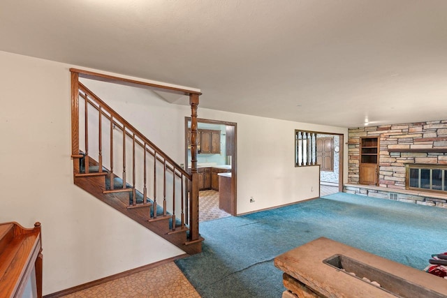 1490 Fernando Dr, Ashwaubenon, WI 54115 - unfurnished living room featuring built in shelves, stairs, a fireplace, and carpet flooring