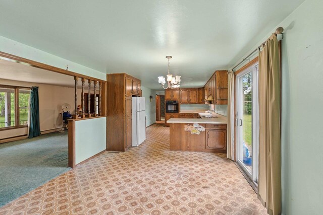 1490 Fernando Dr, Ashwaubenon, WI 54115 - kitchen featuring black oven, freestanding refrigerator, brown cabinets, a chandelier, and a peninsula