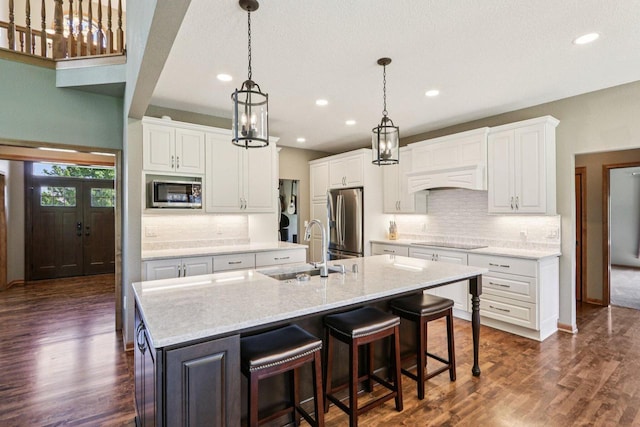 13745 W Park Central Blvd, New Berlin, WI 53151 - kitchen with appliances with stainless steel finishes, a center island with sink, white cabinetry, recessed lighting, and dark wood finished floors