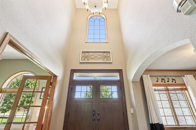 13745 W Park Central Blvd, New Berlin, WI 53151 - foyer entrance featuring arched walkways, a textured wall, a towering ceiling, and healthy amount of natural light