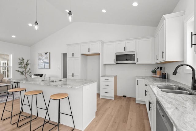 2061 White Dove Ln, Kaukauna, WI 54130 - kitchen featuring stainless steel appliances, a kitchen bar, white cabinetry, light stone countertops, and a center island