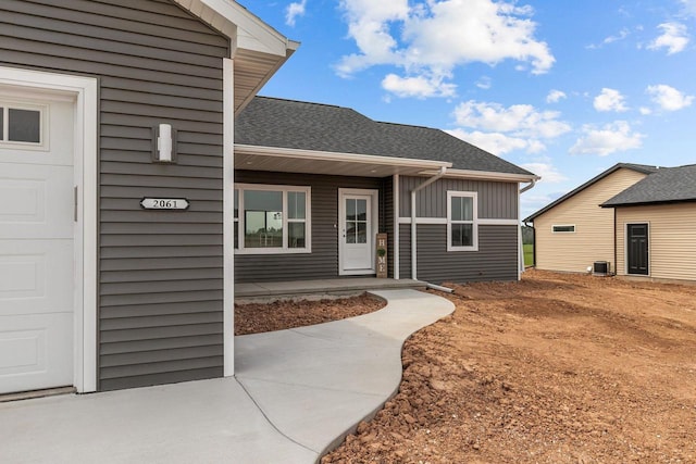 2061 White Dove Ln, Kaukauna, WI 54130 - property entrance with a porch, a shingled roof, and board and batten siding