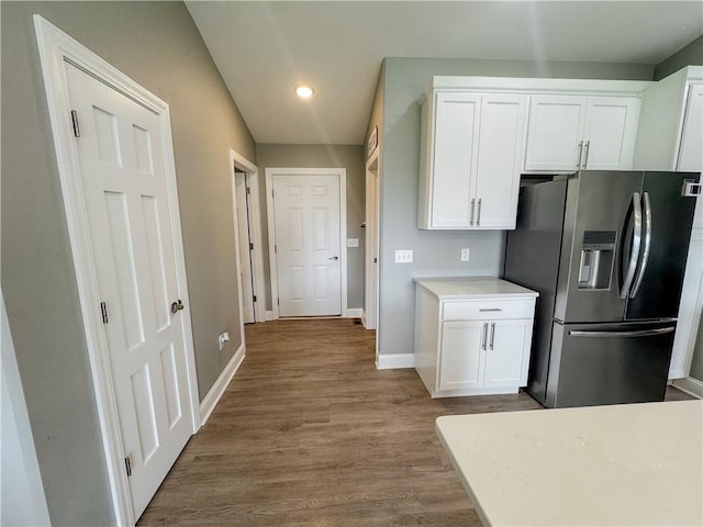 406 S Birch St, Marshfield, WI 54449 - kitchen with stainless steel fridge with ice dispenser, white cabinets, wood finished floors, recessed lighting, and light countertops