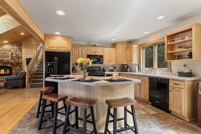 4721 Lake Of The Woods Rd, Sturgeon Bay, WI 54235 - kitchen featuring black appliances, light brown cabinets, a breakfast bar area, and recessed lighting