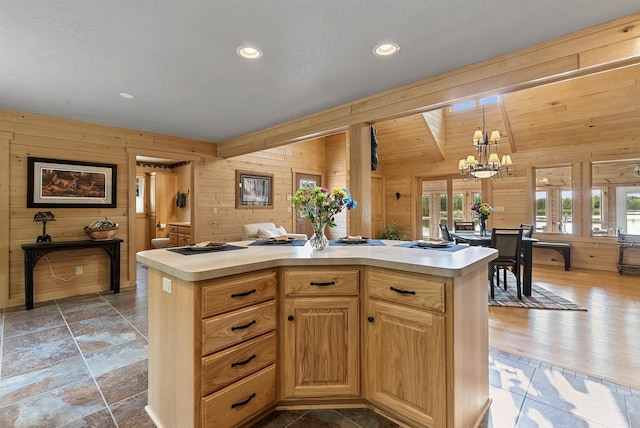 4721 Lake Of The Woods Rd, Sturgeon Bay, WI 54235 - kitchen with wooden walls, light countertops, a chandelier, a center island, and pendant lighting