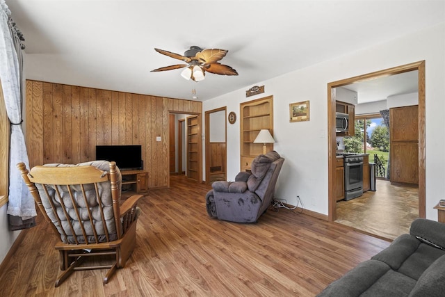 238 N State St, Chilton, WI 53014 - living room featuring ceiling fan, wooden walls, and wood finished floors