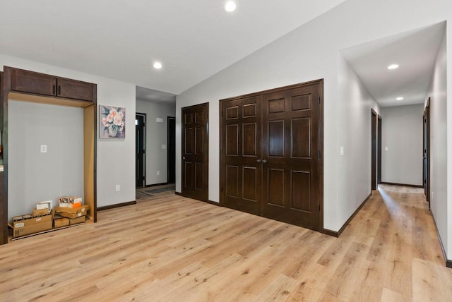 997 E Sunnyview Rd, Oshkosh, WI 54901 - unfurnished bedroom with light wood-type flooring, lofted ceiling, recessed lighting, and multiple closets