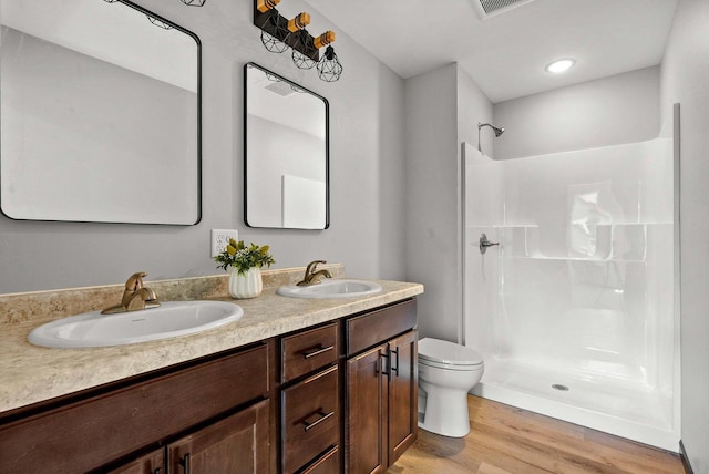 997 E Sunnyview Rd, Oshkosh, WI 54901 - full bath featuring double vanity, a shower, and wood finished floors