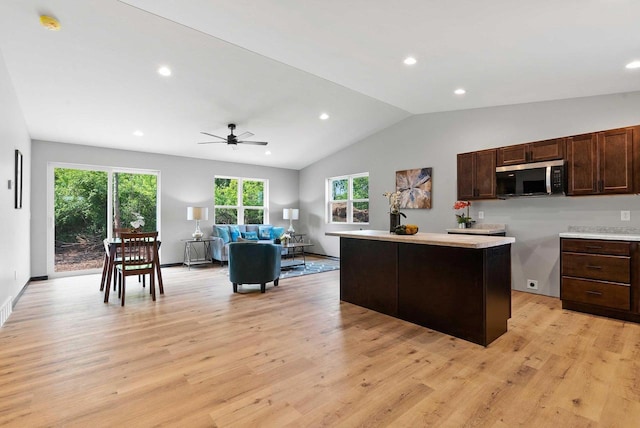 997 E Sunnyview Rd, Oshkosh, WI 54901 - kitchen featuring stainless steel microwave, dark brown cabinetry, light wood finished floors, lofted ceiling, and recessed lighting