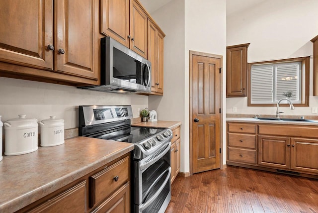 4835 Isabella Cir, Hobart, WI 54155 - kitchen featuring appliances with stainless steel finishes, brown cabinetry, dark wood-style floors, and light countertops
