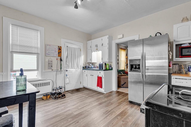628 End Ct Unit 628A, Sheboygan, WI 53081 - kitchen with stainless steel fridge with ice dispenser, radiator heating unit, electric stove, light wood-style floors, and white cabinets