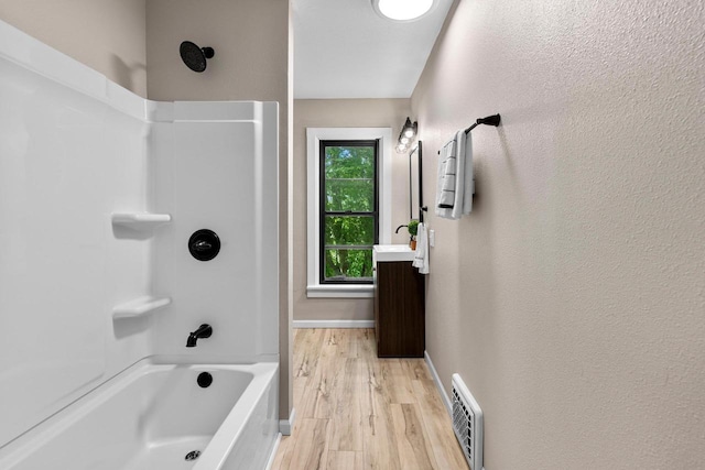 907 Lawe St, Kaukauna, WI 54130 - full bathroom featuring  shower combination, vanity, wood finished floors, and a textured wall