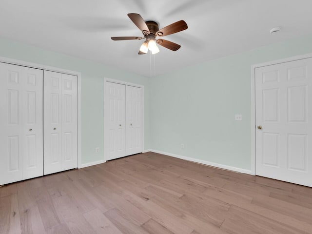 8300 Fishman Rd, Burlington, WI 53105 - unfurnished bedroom with multiple closets, light wood-type flooring, and a ceiling fan