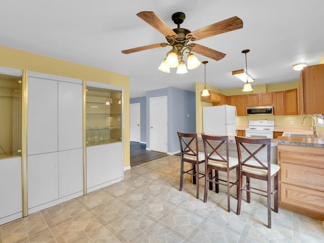 8300 Fishman Rd, Burlington, WI 53105 - kitchen with white appliances, a ceiling fan, a peninsula, pendant lighting, and light countertops