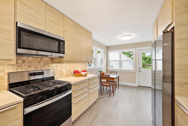 50 S Marquette St, Madison, WI 53704 - kitchen featuring stainless steel appliances, light brown cabinetry, light wood finished floors, and light countertops