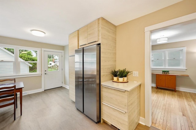50 S Marquette St, Madison, WI 53704 - kitchen featuring freestanding refrigerator, light wood-style floors, light brown cabinetry, and light countertops