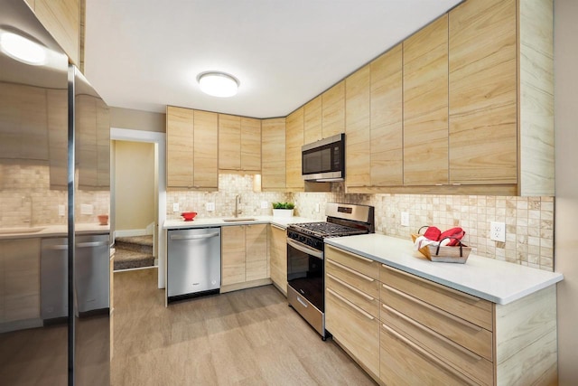 50 S Marquette St, Madison, WI 53704 - kitchen with appliances with stainless steel finishes, light brown cabinets, light wood-style flooring, tasteful backsplash, and light countertops